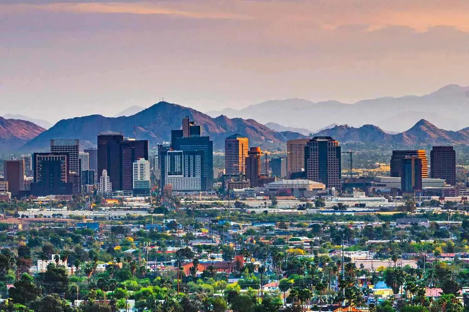 Phoenix, Arizona skyline at dusk with the surrounding desert mountains behind it
