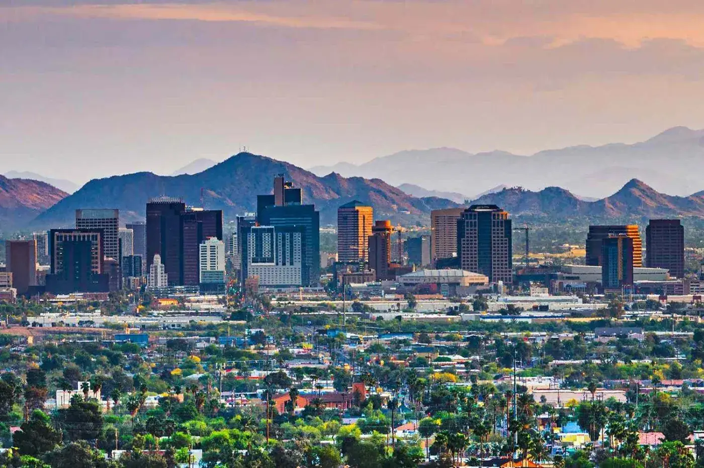 Phoenix skyline at dusk with the desert mountains behind it