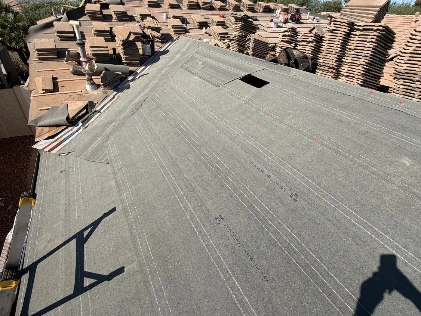 Arizona Tile Roofing job in progress: tile lifted and stacked, new underlayment laid across the roof deck
